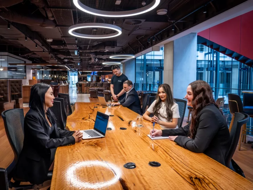 Clients working in a modern coworking room space on a large table in Servcorp 3 Parramatta Square